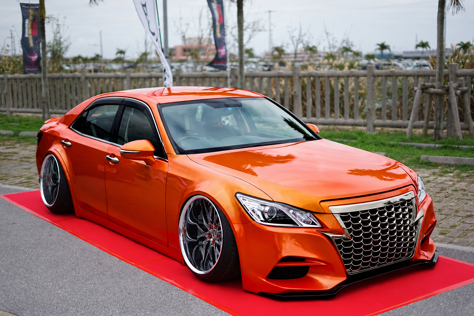 Custom orange sedan displayed at an automotive show